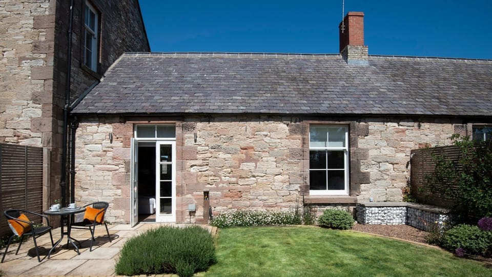 Cambridge House Cottage Number One - the garden with patio area and Cambridge House sitting to the left