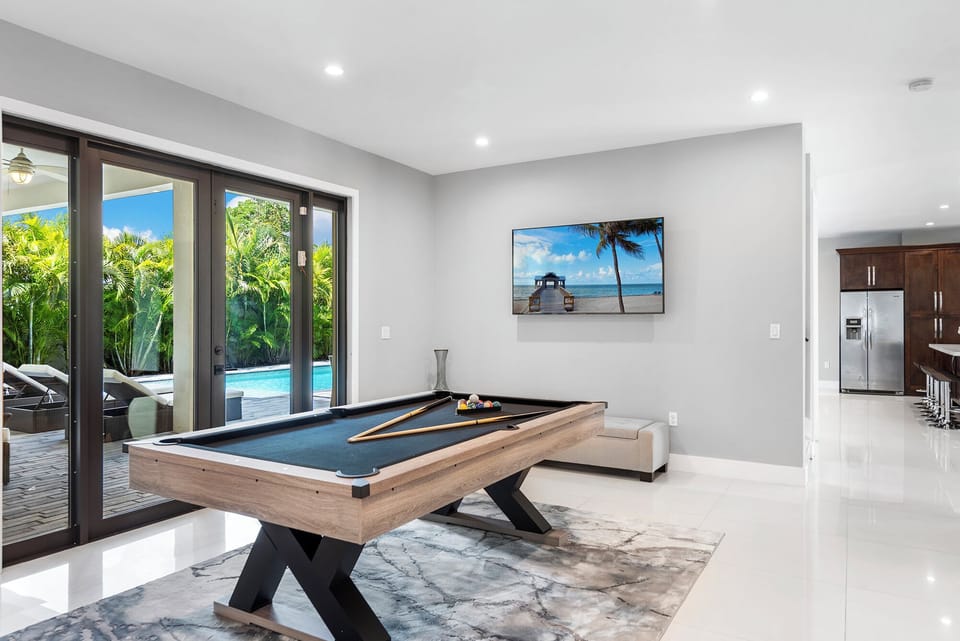 Game room featuring a pool table and sliding glass doors.

