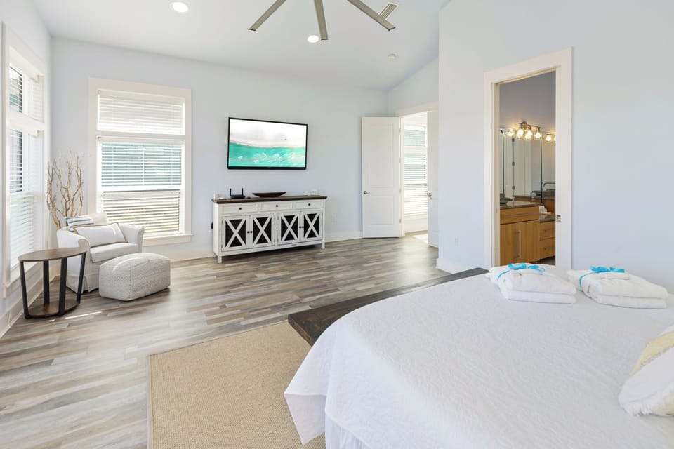 Unwind in your spacious master suite with cozy seating area, flat-screen TV, and luxurious linens awaiting your arrival.
