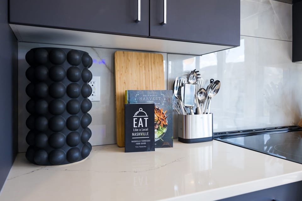 Unit 1: Fully equipped kitchen stocked with basic cooking essentials. Includes stainless steel appliances and kitchen island seating.