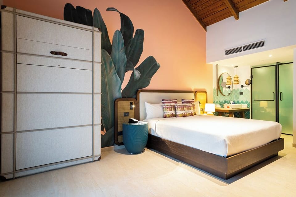 Relax in a designer suite with calming mural and luxe bedding.