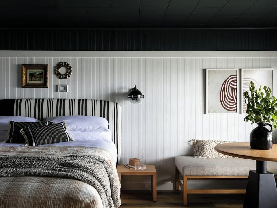 Sink into crisp linens beside warm, inviting designer details.