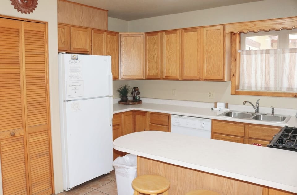Your fully equipped kitchen awaits with warm oak cabinetry, modern appliances, and plenty of counter space for preparing home-cooked meals together.