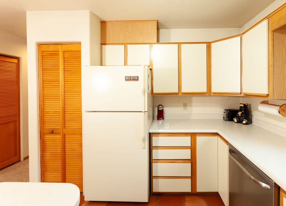 Your fully equipped kitchen with warm oak accents provides everything you need to prepare meals at home. White appliances and generous counter space make cooking effortless and enjoyable.