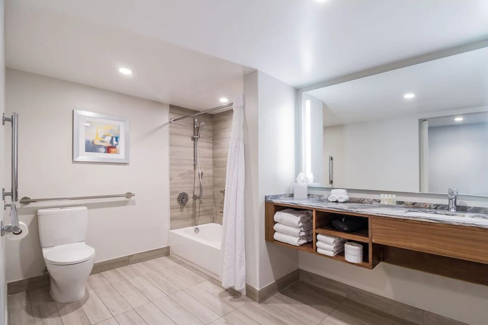Refresh under a sleek shower in a bright spa bath.