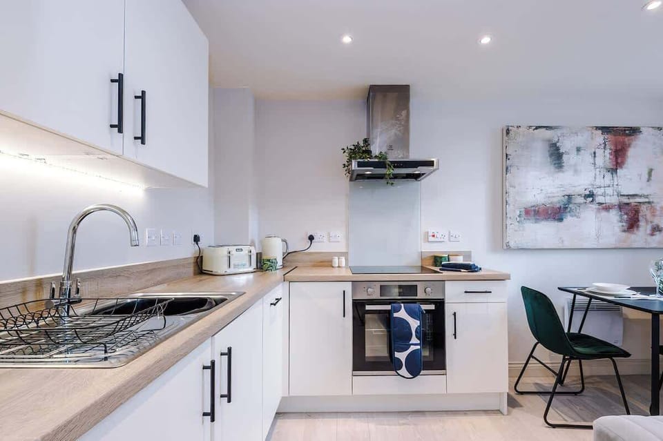 Bright and functional kitchen featuring a sleek stovetop, handy microwave, kettle, and toaster—perfect for cooking light meals or enjoying a cosy breakfast.

