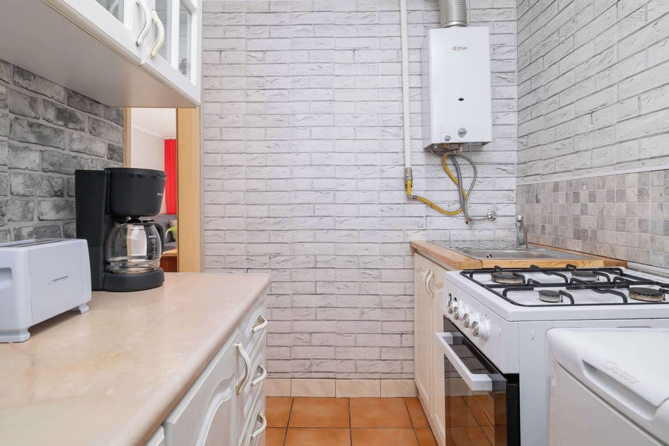 Functional kitchen with gas hob, coffee machine, wooden worktops, and modern finishes.