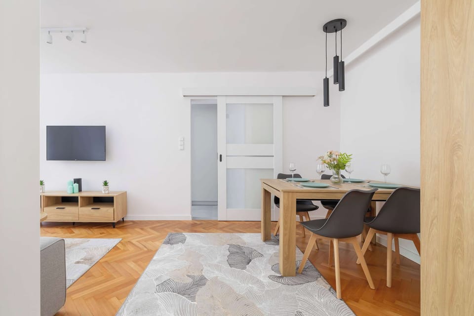 A wide view of the living room and kitchen area with a door leading to the bedroom and lots of open space.