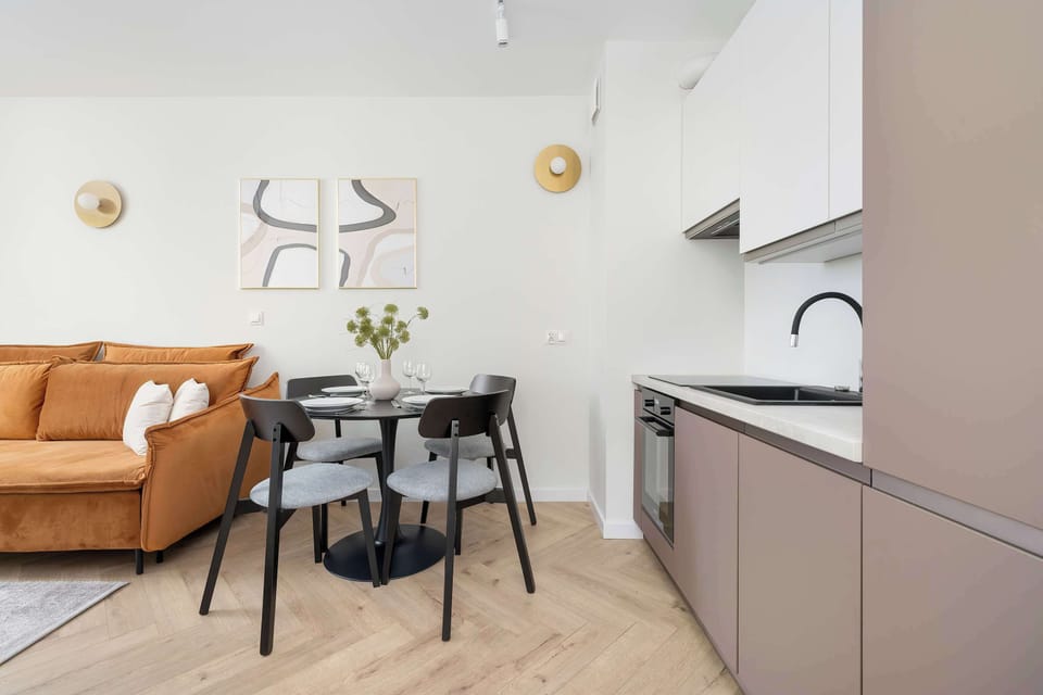 A modern kitchenette with built-in appliances like an oven. The clean lines and neutral colors give it a contemporary feel.