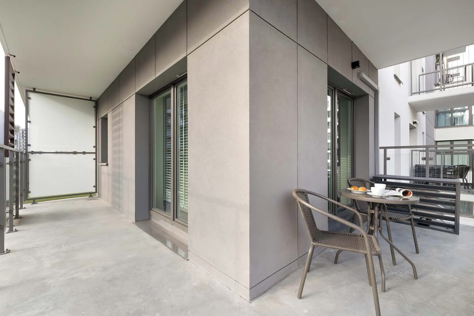 The balcony offers ample space for relaxation, furnished with a small table and chairs. It is perfect for enjoying a morning coffee outdoors.