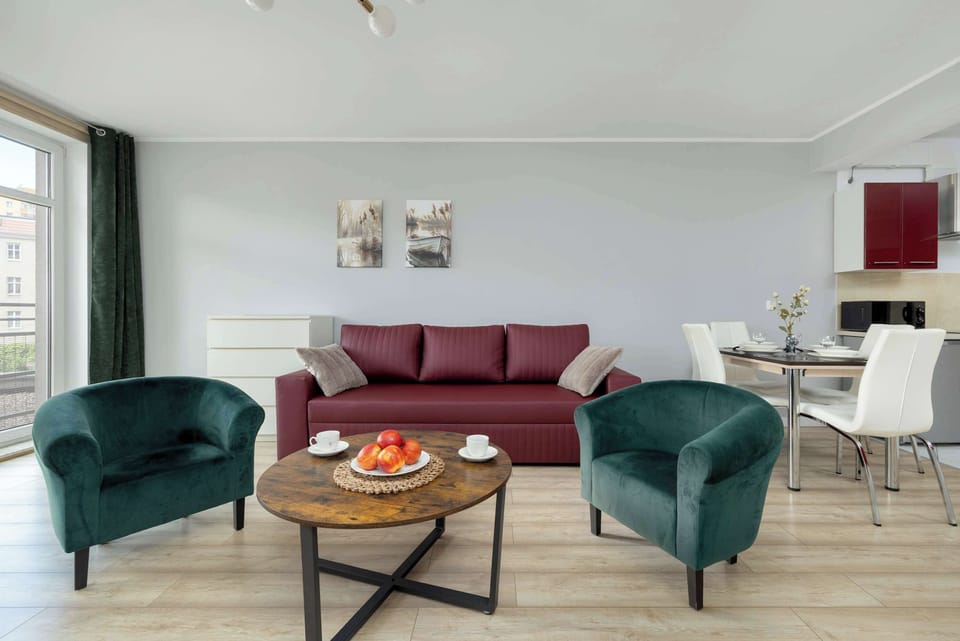 Living room with a fold-out sofa bed, two armchairs, coffee table and TV - ideal for evening relaxation.