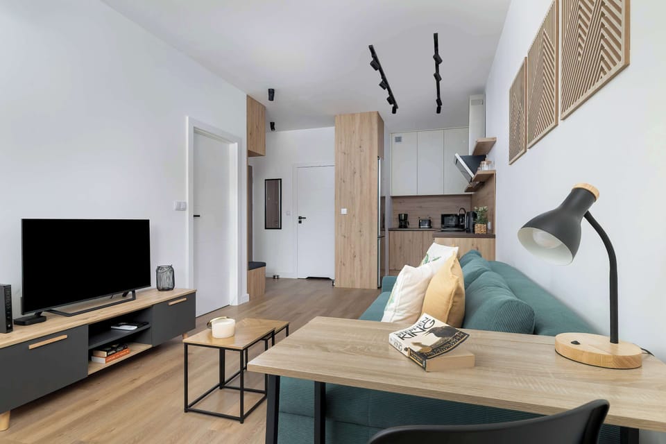 A spacious living room with modern furniture and a large TV provides a comfortable space for everyday relaxation.