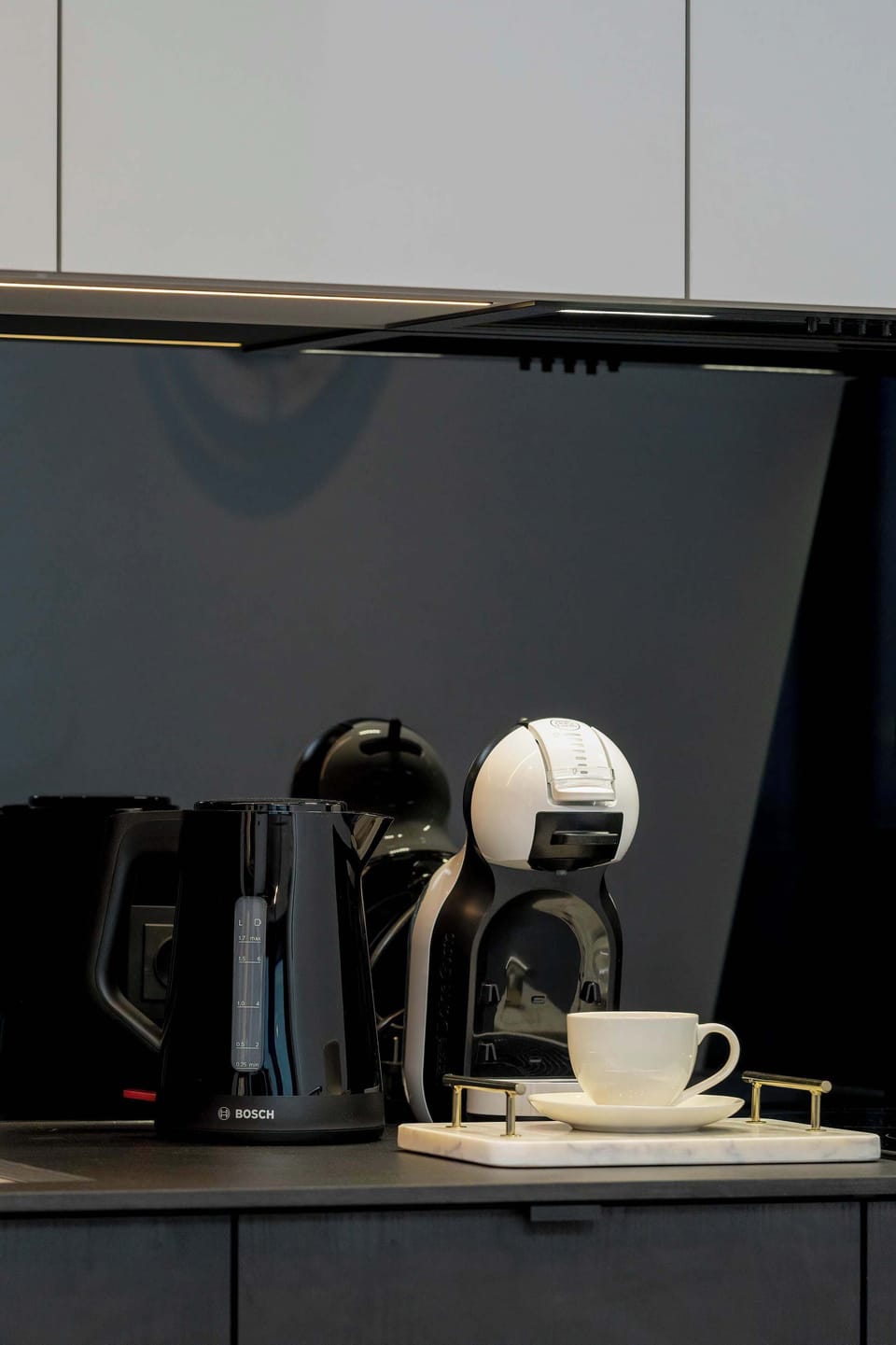 A close-up of a kettle and coffee machine, showcasing their sleek designs and polished surfaces, ready to brew a perfect cup.
