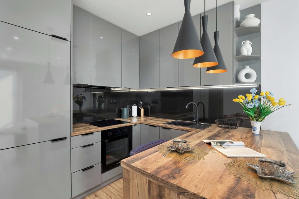 The modern kitchen with a wooden countertop and designer lighting makes cooking a real pleasure.