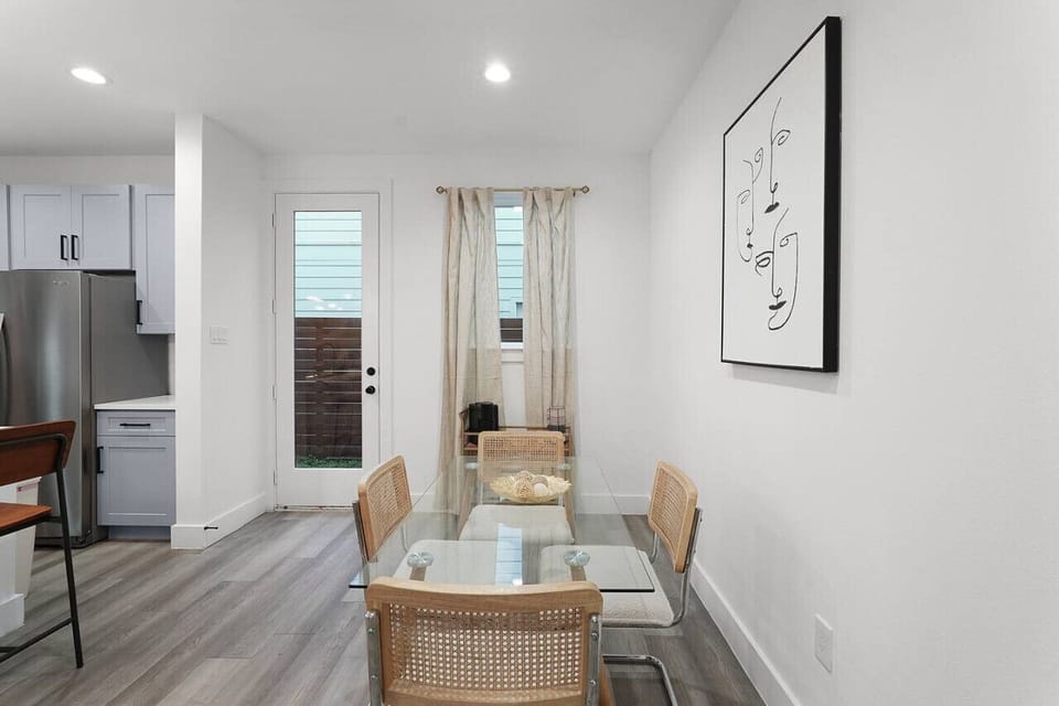 The dining area offers a bright and cozy atmosphere, complemented by minimalist wall art and natural light.