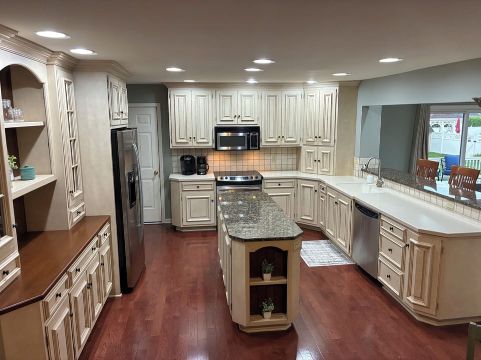 Full kitchen 1 of 2. Granite countertop island and bar. Corian elsewhere.