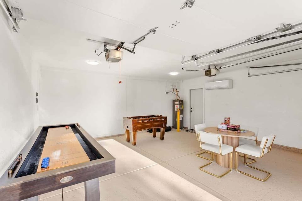 Game room featuring shuffleboard, foosball, and a small dining table stocked with board games.