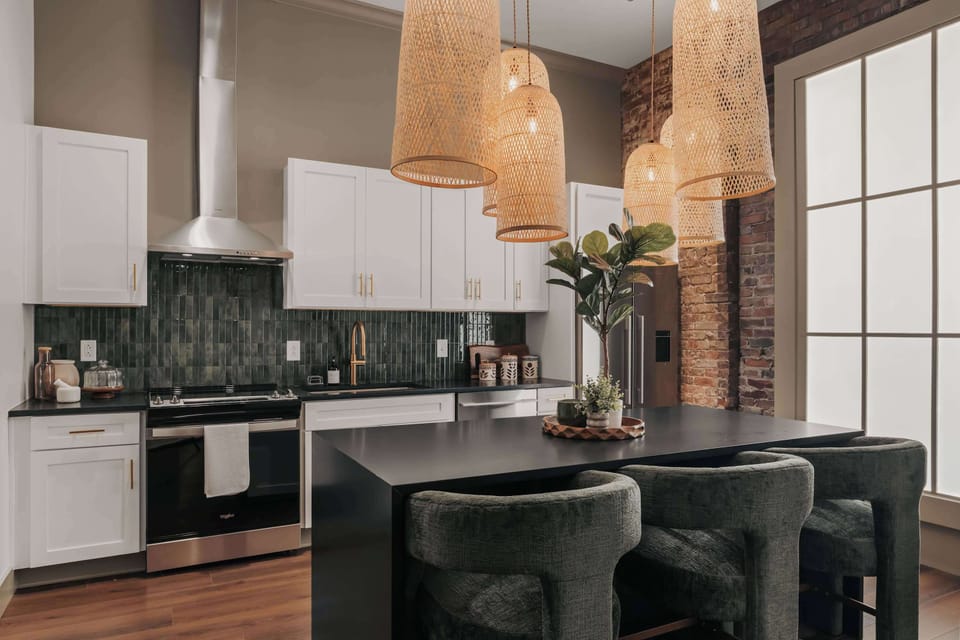 The modern kitchen is fully equipped with everything you need to cook, all accented by playful, earth-inspired chandeliers. A spacious island with plush stools offers additional seating for casual dining or morning coffee.
