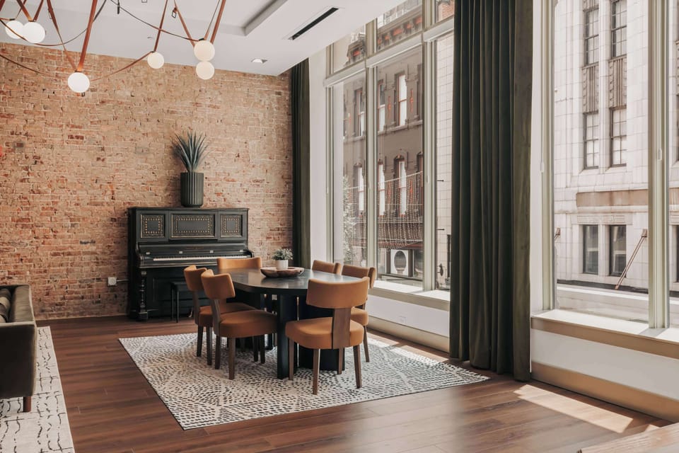 The dining room features a spacious table surrounded by six comfortable, design-forward chairs—perfect for shared meals or game nights.