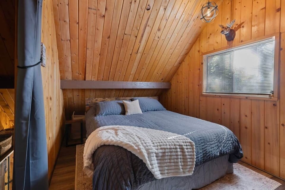 This is an upstairs bedroom, it has a California king bed sitting chair, dresser, luggage rack, fan, window fan and 32 inch tv. Honestly, this is my favorite bed it is seriously comfy.