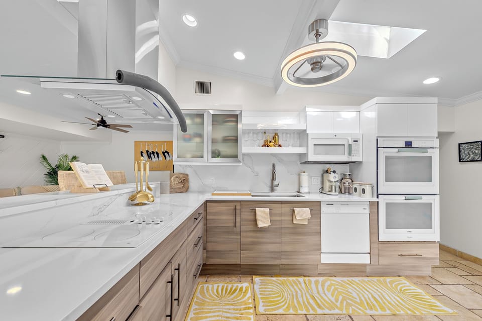Cook with ease in a modern kitchen equipped with light cabinetry, stainless steel appliances, and a range hood—perfect for preparing delicious meals.