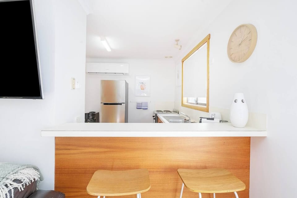 The breakfast bar with stools for two offers a cosy nook to stay connected with the chef, perfect for sharing a drink or keeping company while dinner simmers.