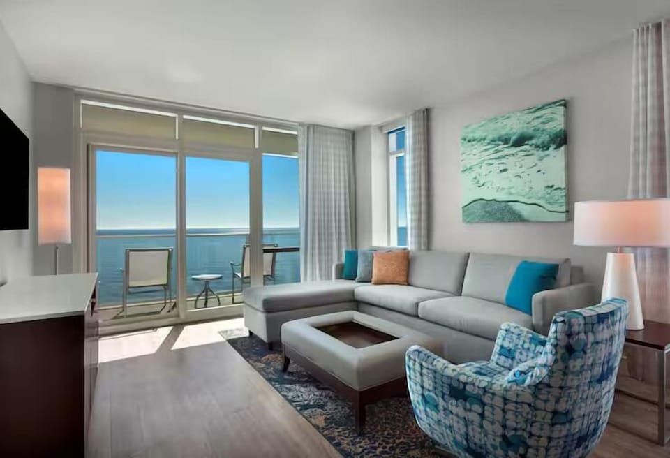 Lounge together in a bright living room with ocean backdrop.