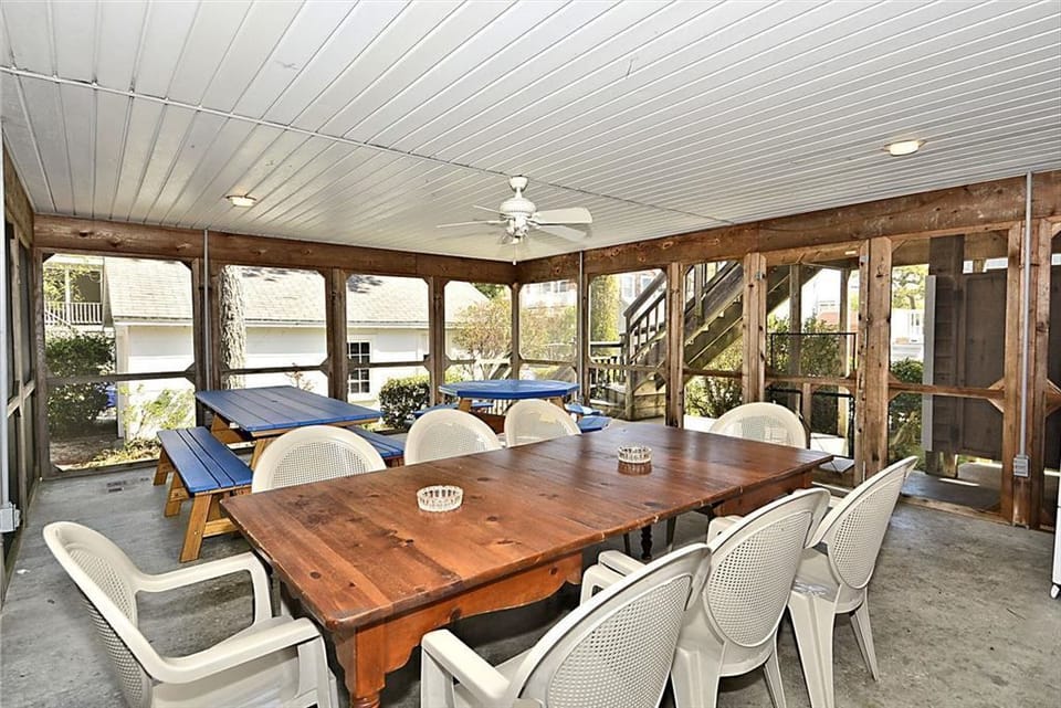 The expansive screened porch is equipped with a large dining table and additional seating, perfect for enjoying meals or socializing while staying sheltered from the elements.