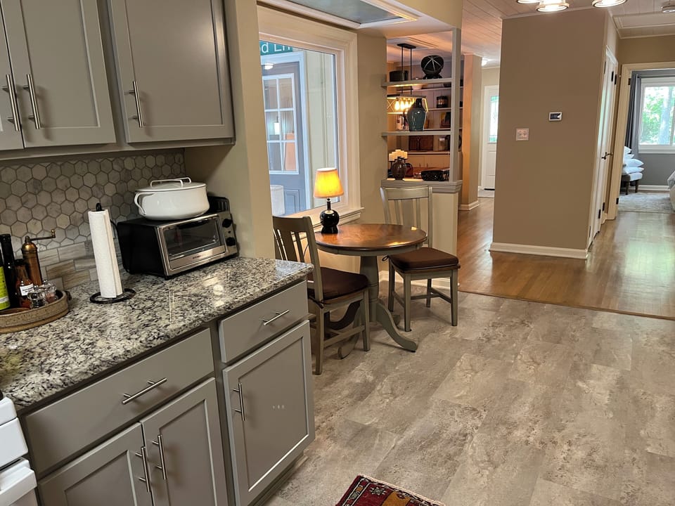 Seating for two in kitchen nook overlooking porch.