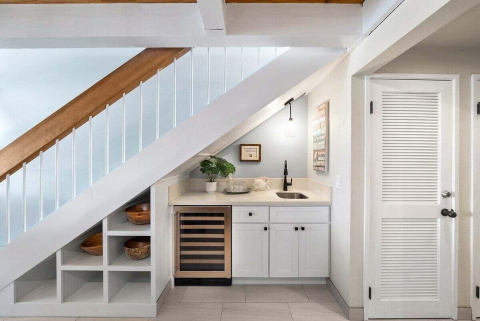 Compact beverage station with modern cabinetry, a wine fridge, and elegant lighting—perfect for entertaining guests