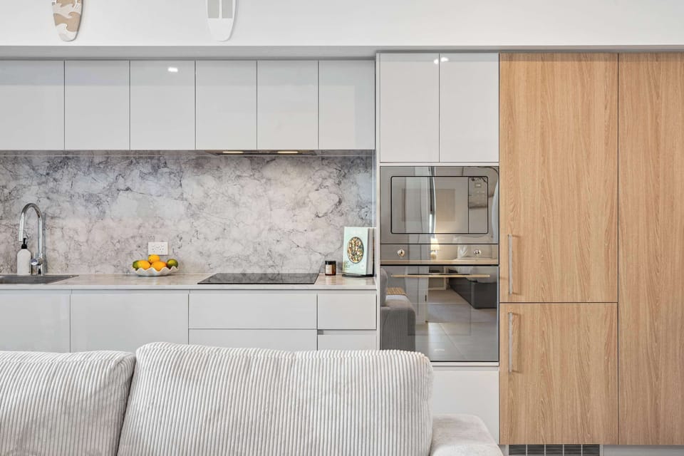 Prepare easy breakfasts or relaxed dinners in the contemporary kitchen designed for calm, coastal living.