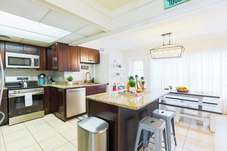 This bright and spacious kitchen comes fully equipped with modern appliances, including a stainless steel refrigerator, microwave, and stove—everything you need to prepare home-cooked meals during your stay.