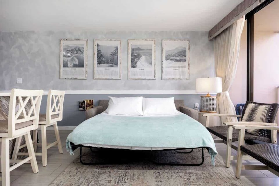 Relax and unwind in this bright, open-concept living area, featuring a pull-out sleeper sofa and direct access to a private balcony with stunning views.