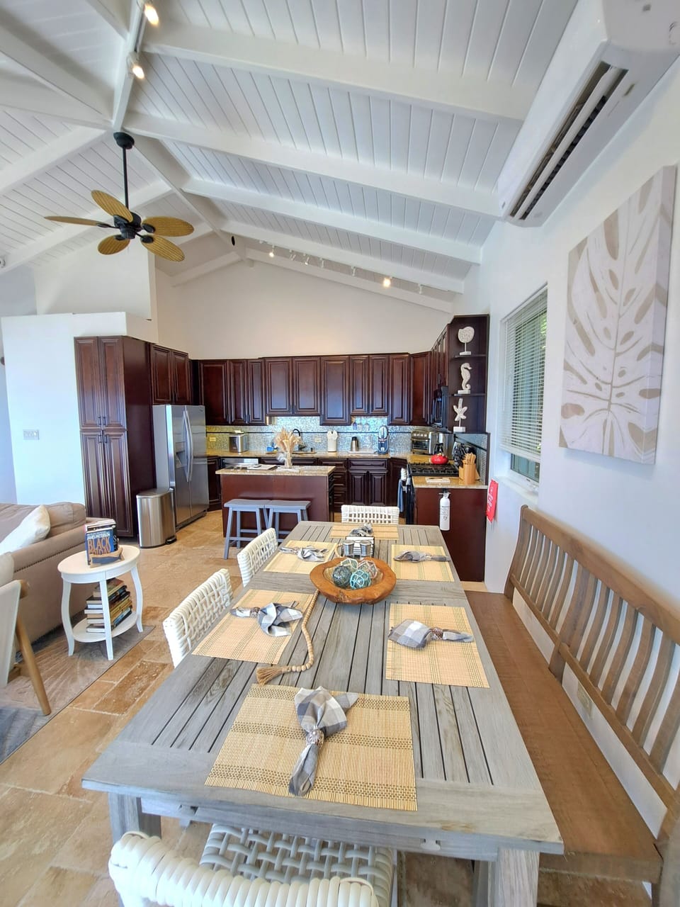 Indoor table and kitchen area. Kitchen is well stocked with cookware etc