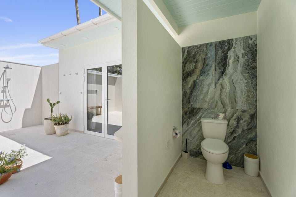 This brand-new outdoor bathroom combines luxury and nature, with a soaking tub and double rain showers in a beautifully designed open setting—perfect for unwinding in true island style.