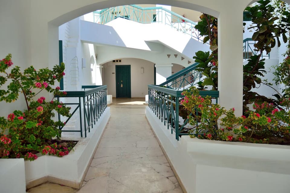 Stroll through crisp white corridors framed by blooming bougainvillea.