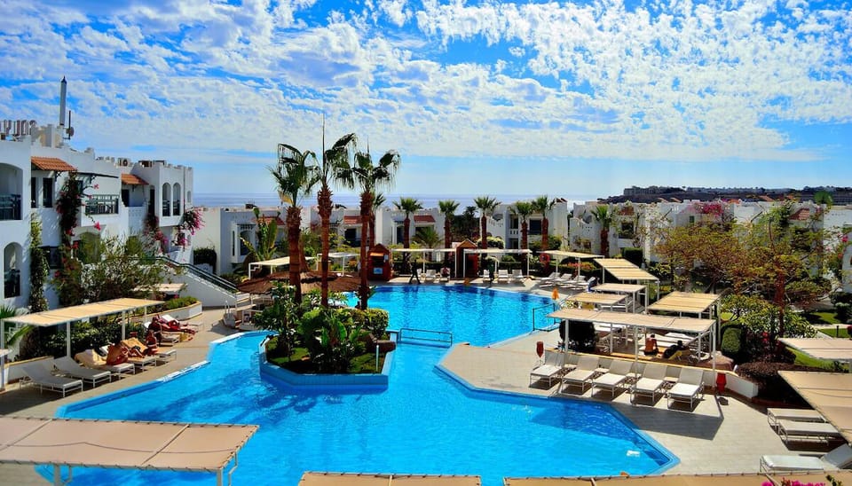 Bask in sunshine by vivid blue pools and shaded daybeds.