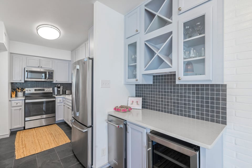 Your fully equipped kitchen features gleaming stainless appliances and elegant white cabinetry, perfect for preparing memorable meals during your stay.