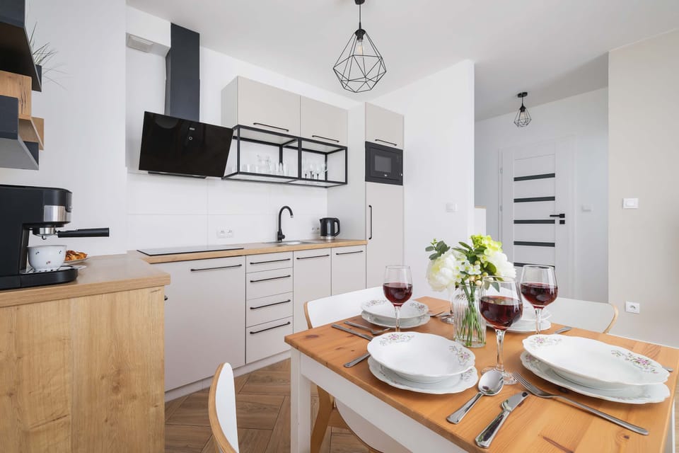 The dining table set for meals along with the view of the studio's lounge area creates a harmonious and practical space.