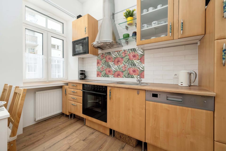 A small kitchen featuring a tiled backsplash, modern appliances, and a cozy layout.