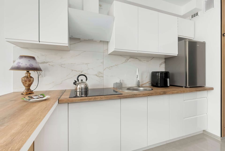 Modern white kitchen with wooden countertops and all essentials.
