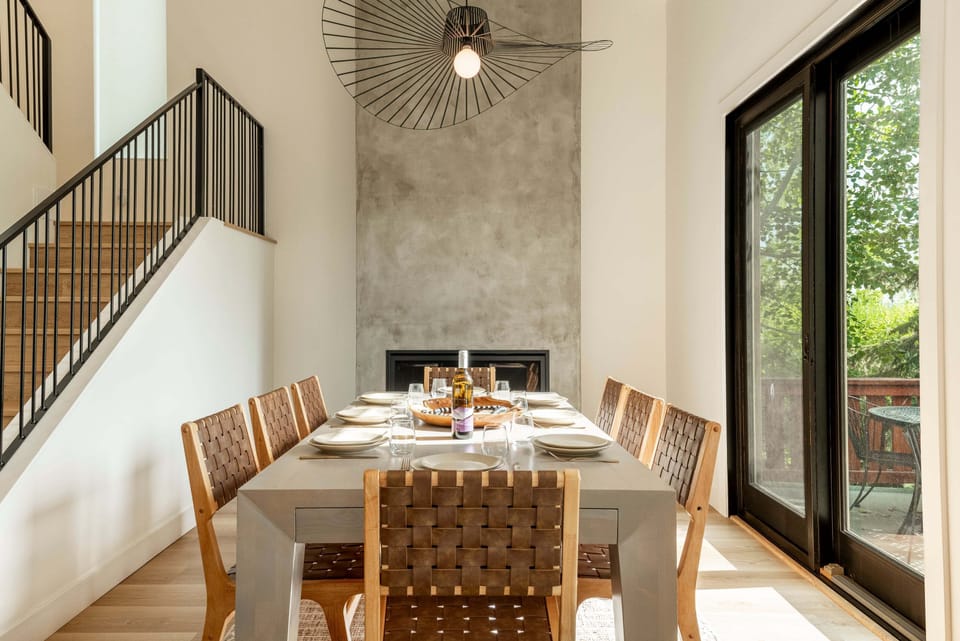 Dining Table for 8 situated next to a gorgeous gas fireplace and balcony