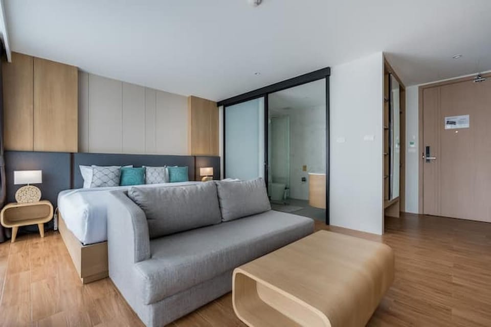 Spacious bedroom featuring a seating area, coffee table, and queen-size bed.