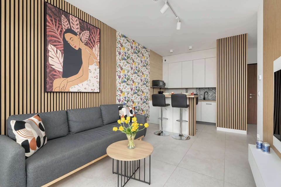 Living room with a fold-out sofa bed, TV and dining area with kitchenette.