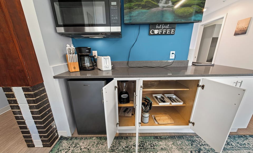 Stocked kitchenette w/ fridge, microwave, coffee maker & dishes for easy meals.