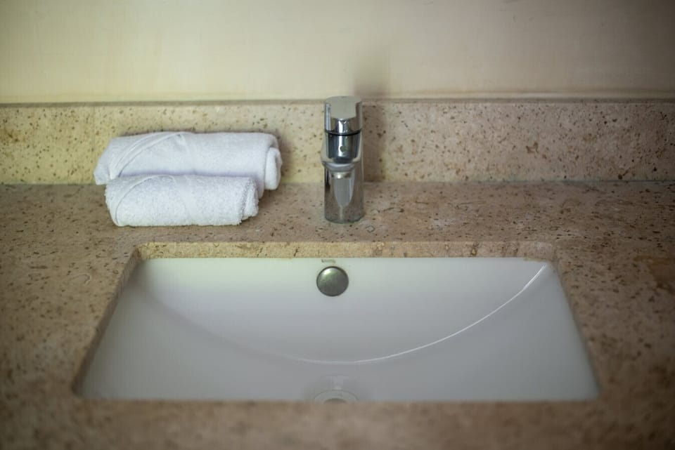 Modern sink with chrome faucet and marble finish.