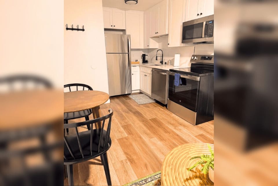 Fully equipped modern kitchen with stainless steel appliances and quartz counters.
