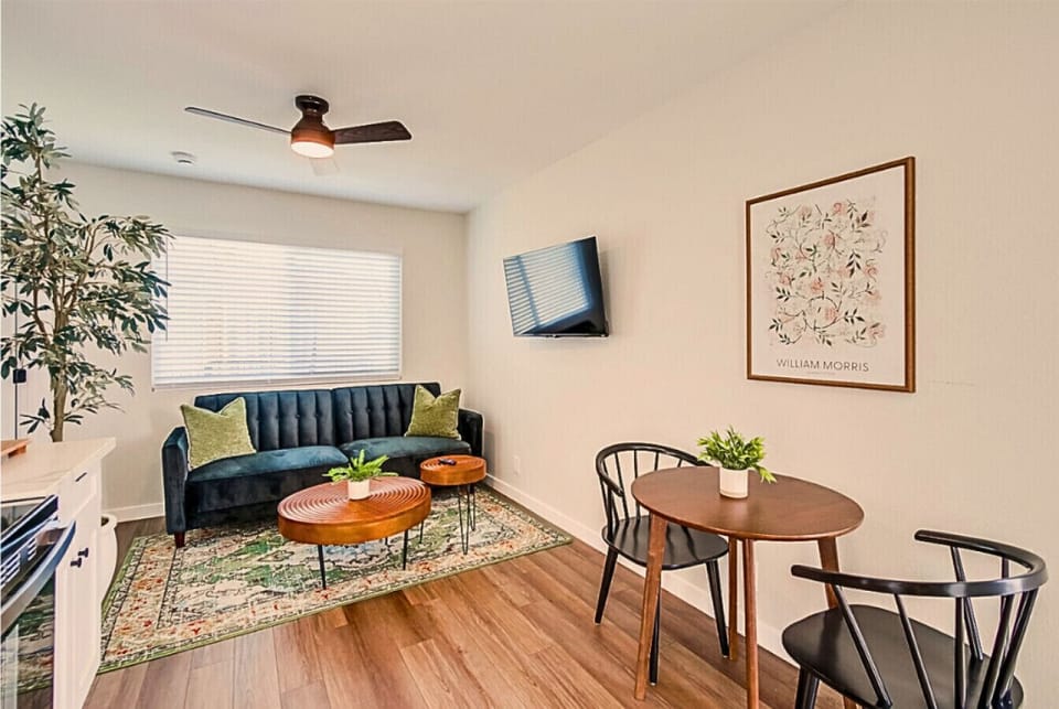 Charming living space with smart TV, plush sofa, and a small dining nook.