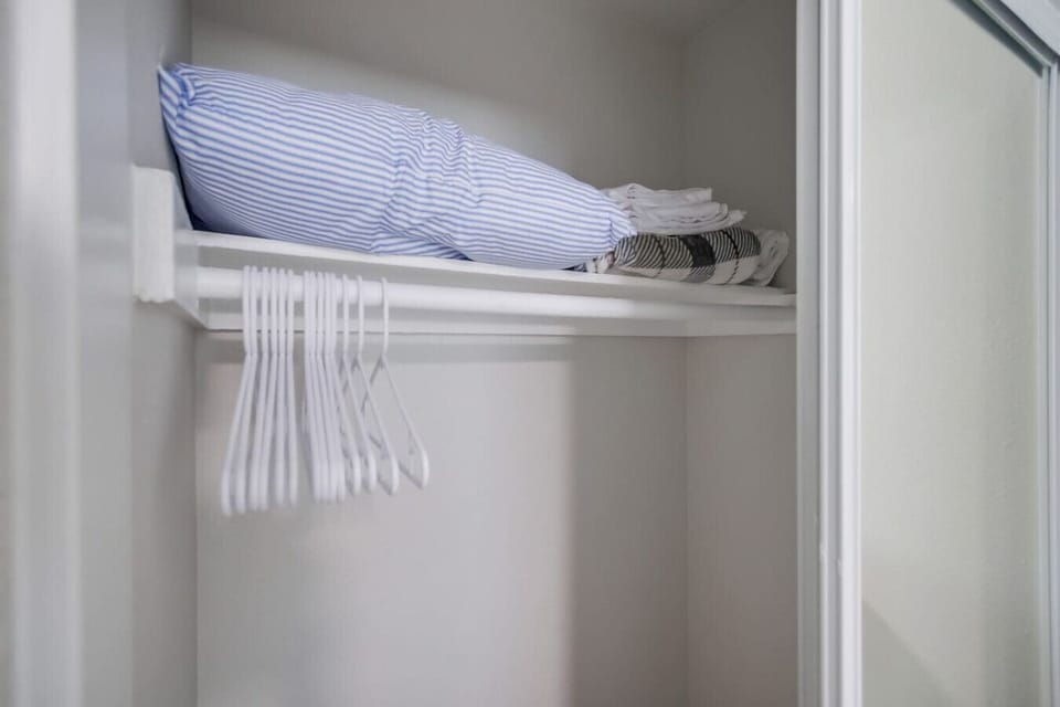 Spacious closet with extra linens and plenty of hangers.