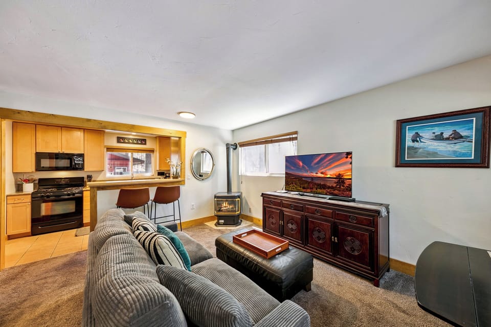 Cozy up in your spacious living area with plush seating, warming fireplace, and fully equipped kitchen—perfect for relaxing evenings.